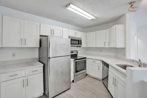 a kitchen with cabinets stainless steel appliances and a counter space