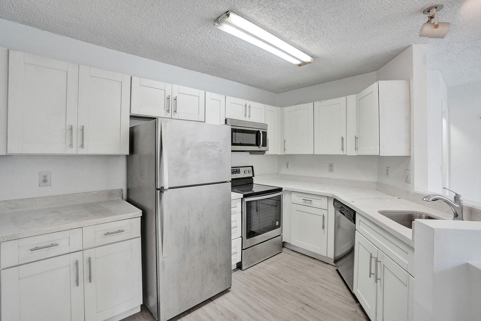 4015 West McNab Road, Unit D204 Pompano Beach, FL 33069 - Photo 13 of 46 a kitchen with cabinets stainless steel appliances and a counter space