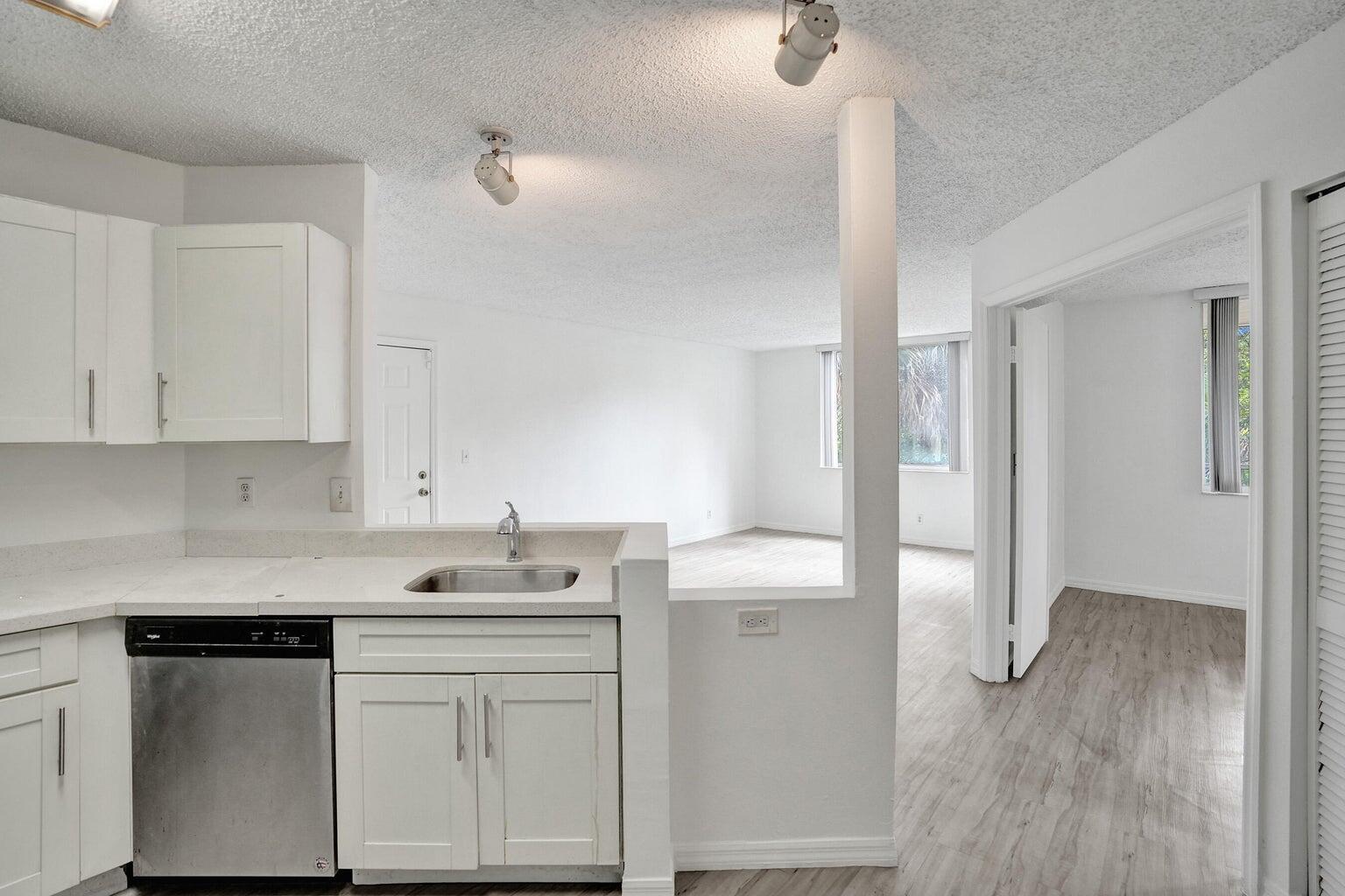 4015 West McNab Road, Unit D204 Pompano Beach, FL 33069 - Photo 14 of 46 a kitchen with white cabinets and sink
