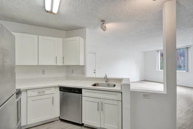 a kitchen with white cabinets and sink