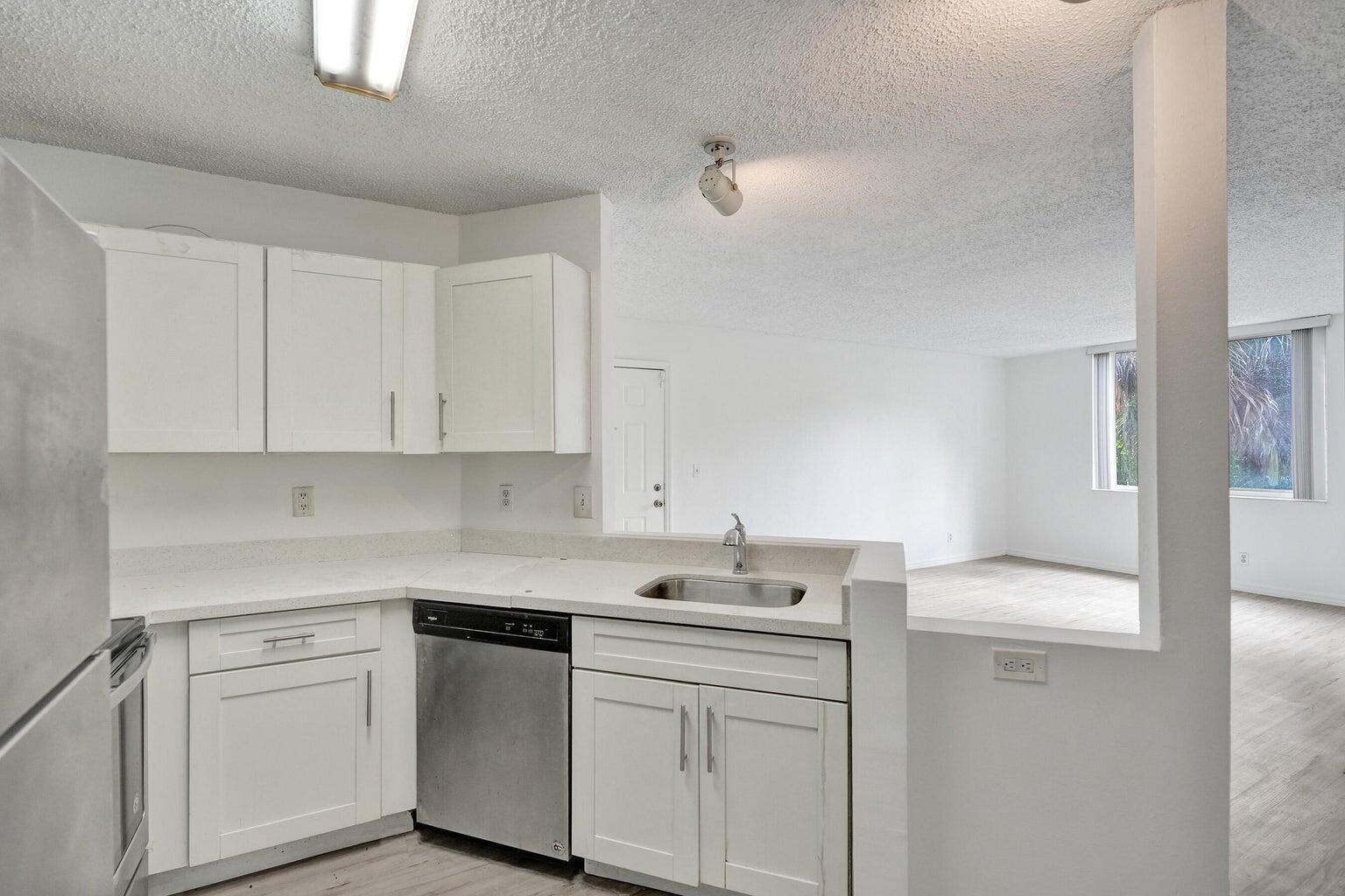 4015 West McNab Road, Unit D204 Pompano Beach, FL 33069 - Photo 15 of 46 a kitchen with white cabinets and sink