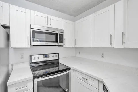 a kitchen with cabinets appliances and a counter space