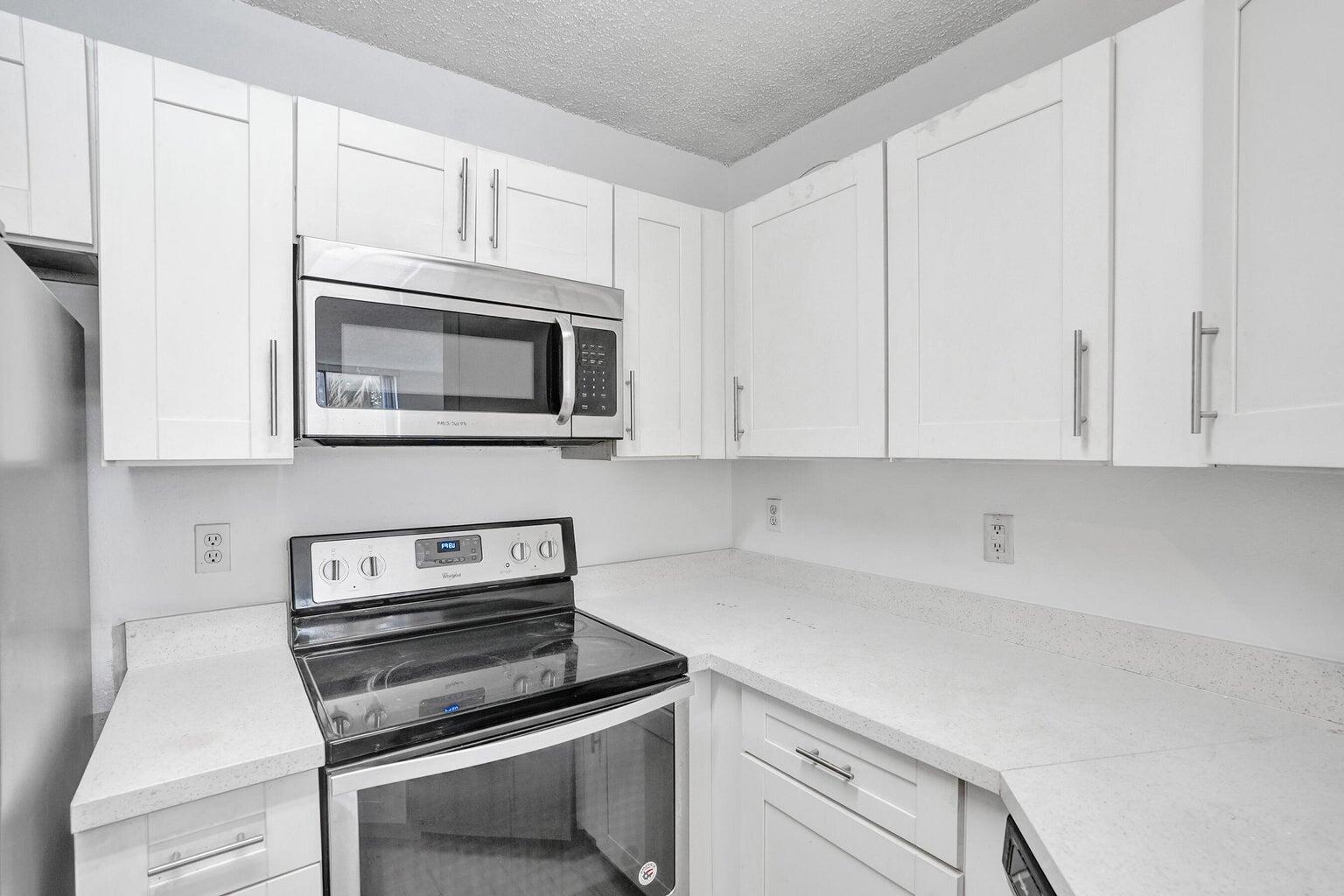4015 West McNab Road, Unit D204 Pompano Beach, FL 33069 - Photo 16 of 46 a kitchen with cabinets appliances and a counter space