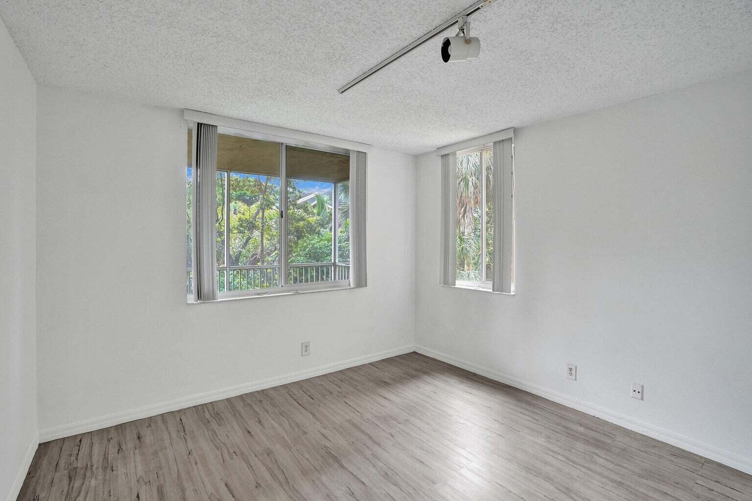 4015 West McNab Road, Unit D204 Pompano Beach, FL 33069 - Photo 17 of 46 an empty room with wooden floor and windows