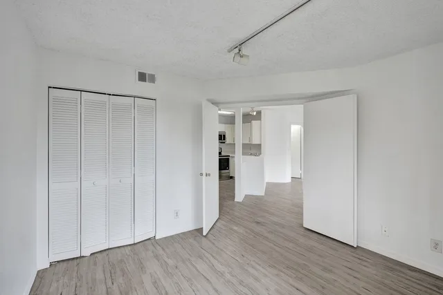 a view of empty room with wooden floor