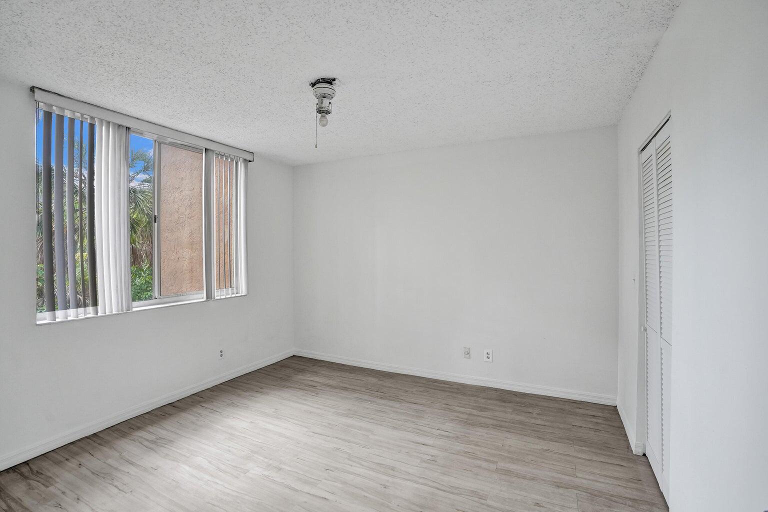 4015 West McNab Road, Unit D204 Pompano Beach, FL 33069 - Photo 25 of 46 a view of an empty room with wooden floor and a window