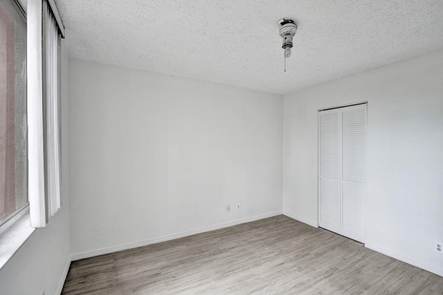 4015 West McNab Road, Unit D204 Pompano Beach, FL 33069 - Photo 28 of 46 a view of an empty room with wooden floor and a window