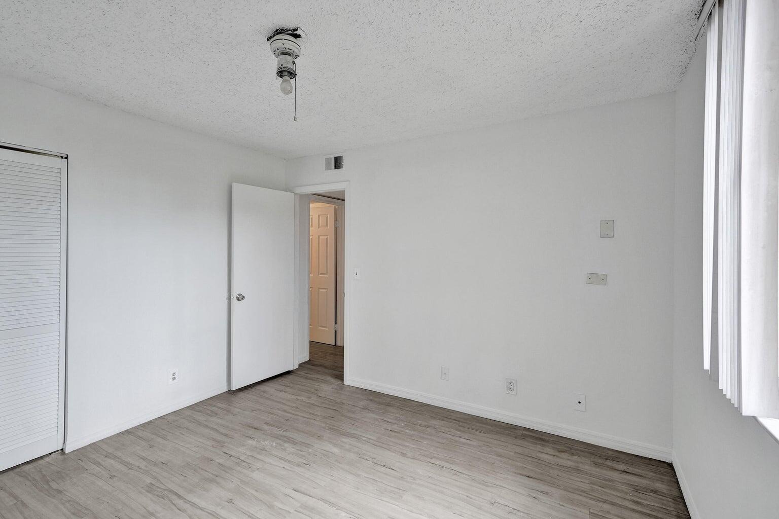 4015 West McNab Road, Unit D204 Pompano Beach, FL 33069 - Photo 30 of 46 an empty room with wooden floor and windows