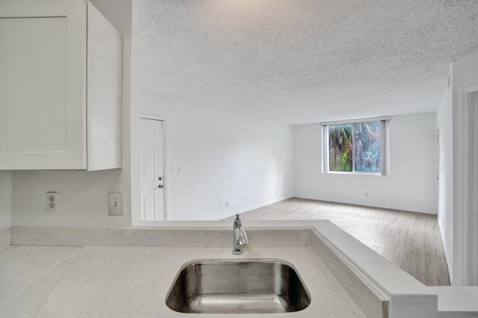 4015 West McNab Road, Unit D204 Pompano Beach, FL 33069 - Photo 35 of 46 a kitchen with a sink and chandelier