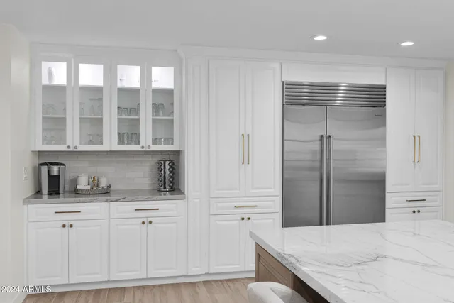 a kitchen with white cabinets and refrigerator