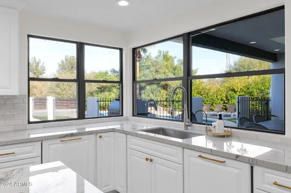 a kitchen with a large window sink and cabinets