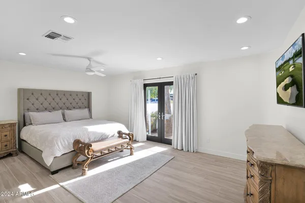 a bedroom with a bed and painting on the wall