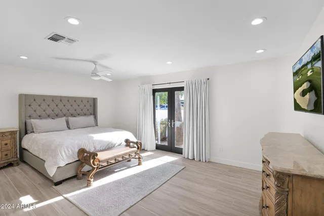 a bedroom with a bed and painting on the wall