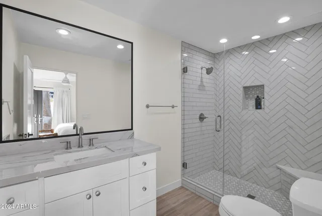 a bathroom with a granite countertop sink a toilet and shower