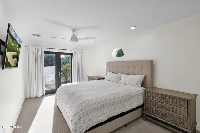 a bedroom with a bed window and a flat screen tv
