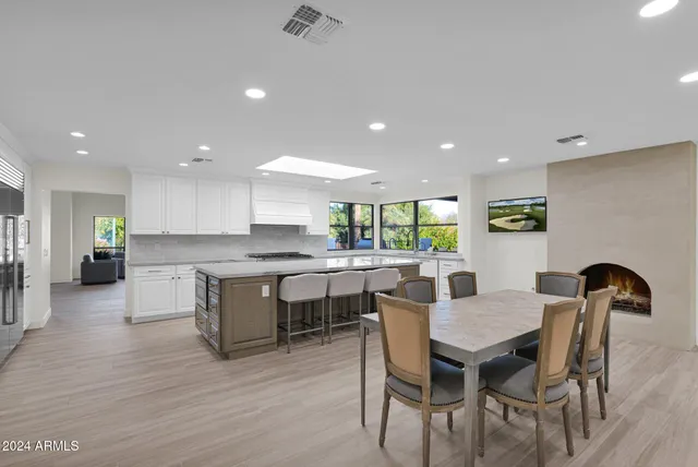 a kitchen with a dining table chairs with wooden floor