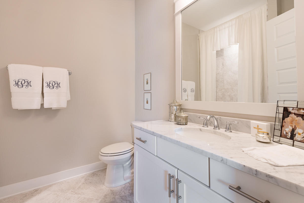 104 Milestone Dr Inlet Beach, Unit A Inlet Beach, FL 32461 - Photo 8 of 10 a bathroom with a granite countertop sink a toilet and a mirror