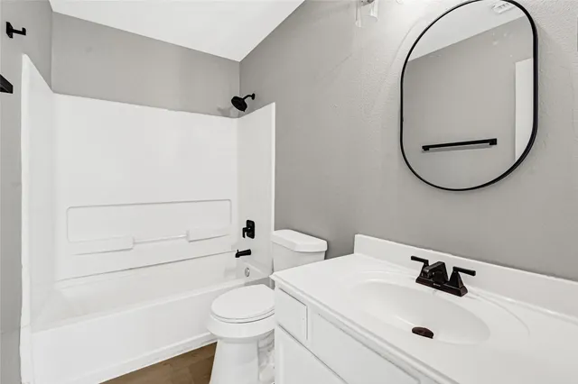 a bathroom with a sink a toilet and a mirror