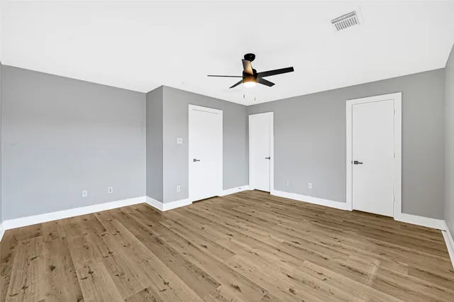 a view of room with wooden floor and ceiling fan