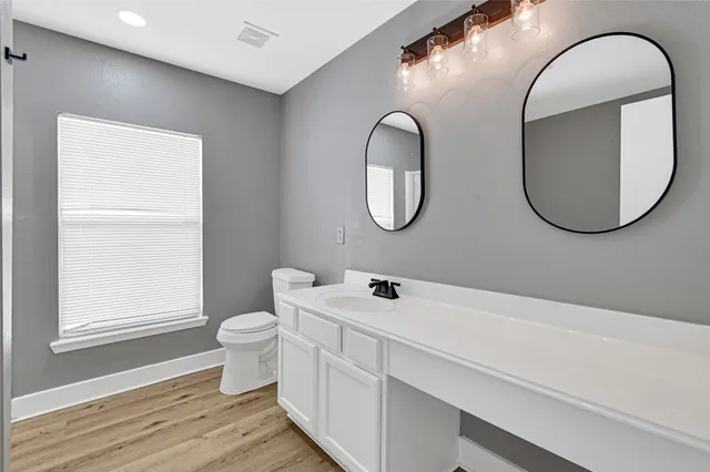 a bathroom with a toilet a sink and a mirror
