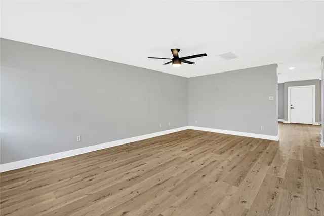 a view of room with wooden floor and ceiling fan
