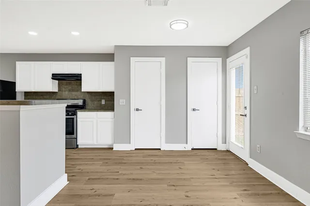 a view of kitchen with granite countertop cabinets and refrigerator