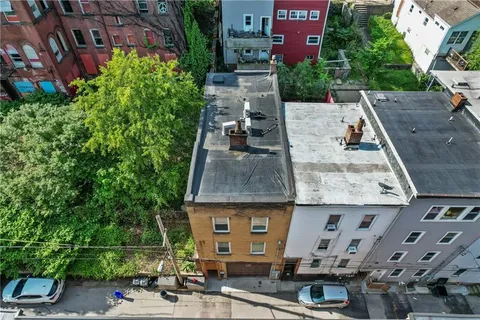 an aerial view of residential houses with outdoor space and trees