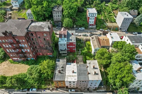 an aerial view of residential houses with outdoor space and trees