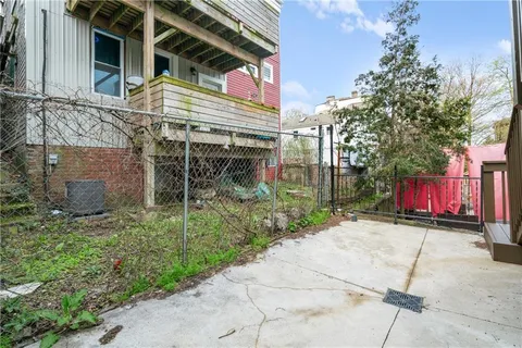 a view of a wooden house with a small yard and wooden fence