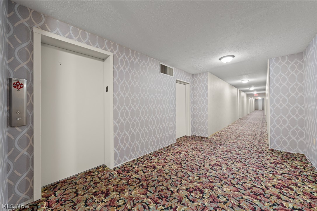 3064 Kent Road, Unit 101 Stow, OH 44224 - Photo 4 of 40 Corridor featuring patterned wallpaper, recessed ceiling lighting, a textured ceiling, and a patterned carpet