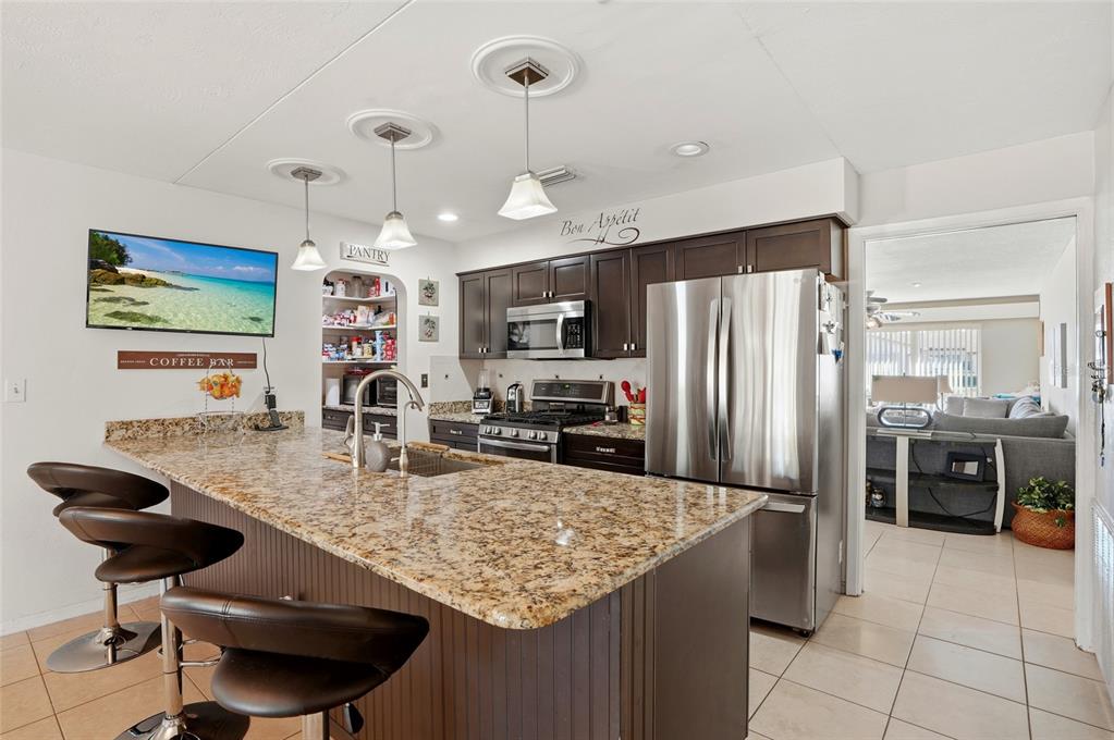 6641 12th Avenue North St. Petersburg, FL 33710 - Photo 2 of 18 a kitchen with stainless steel appliances granite countertop a sink refrigerator and cabinets
