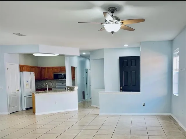 a kitchen with stainless steel appliances kitchen island granite countertop a refrigerator and a sink