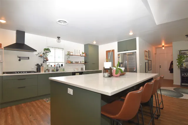 a kitchen with stainless steel appliances granite countertop a sink a stove a table and chairs