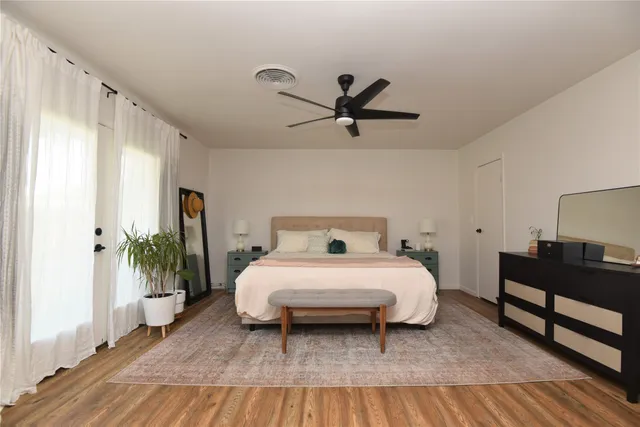 a bedroom with a bed lamp and a potted plant