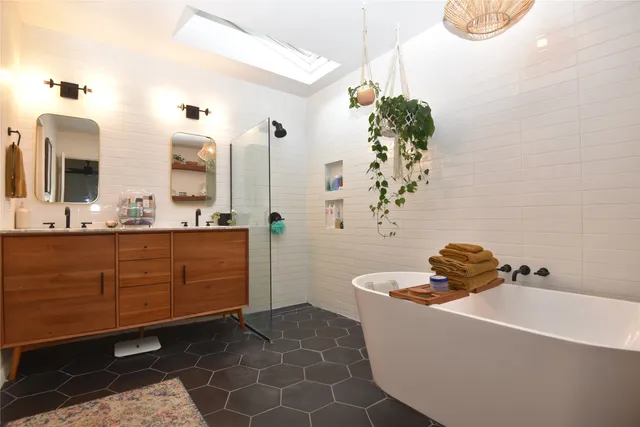 a bathroom with a bathtub sink and mirror