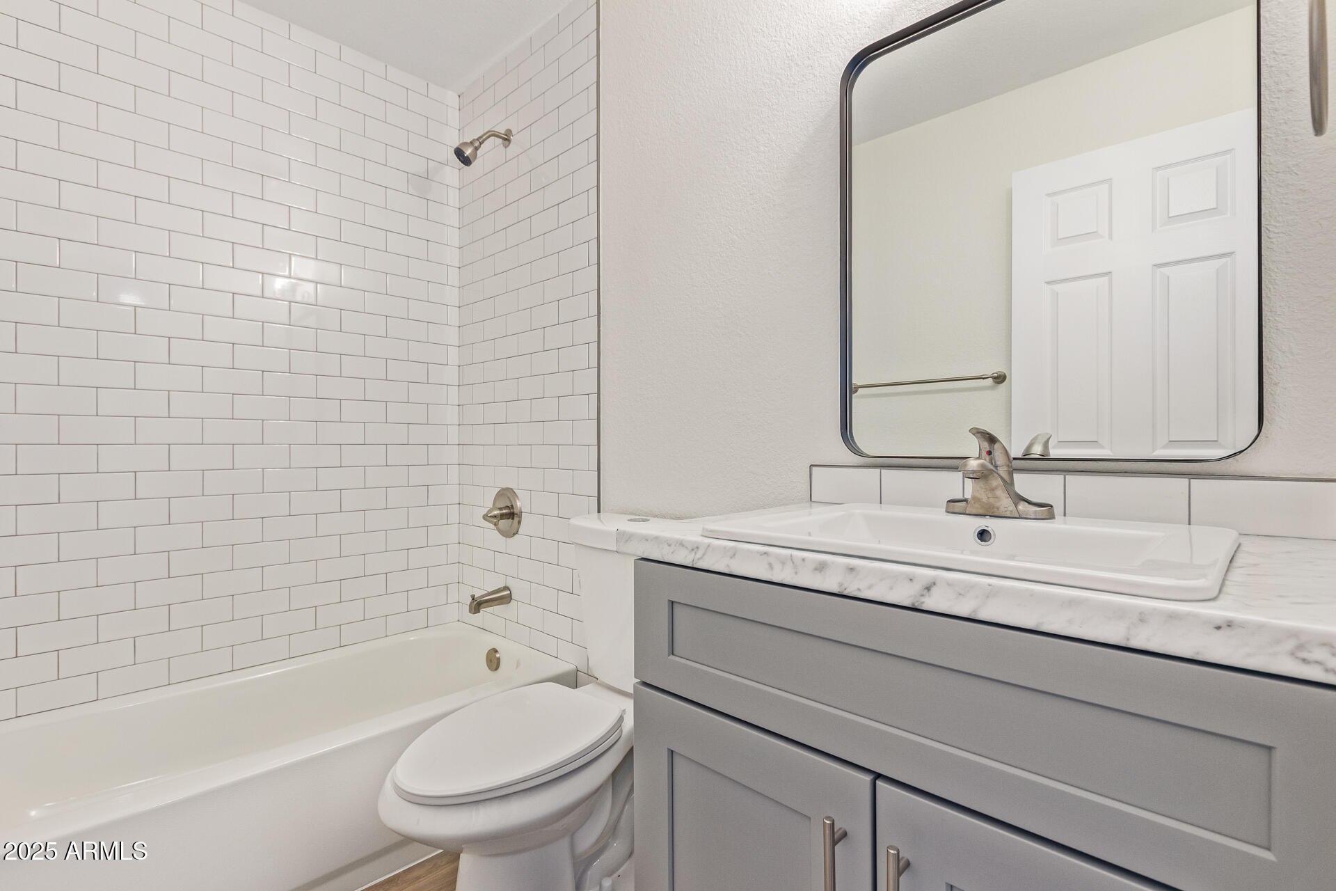 1432 East Broadway Road Mesa, AZ 85204 - Photo 13 of 13 a bathroom with a granite countertop toilet a sink a mirror a bathtub and shower