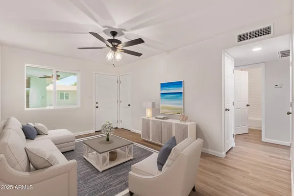 a living room with furniture and a wooden floor