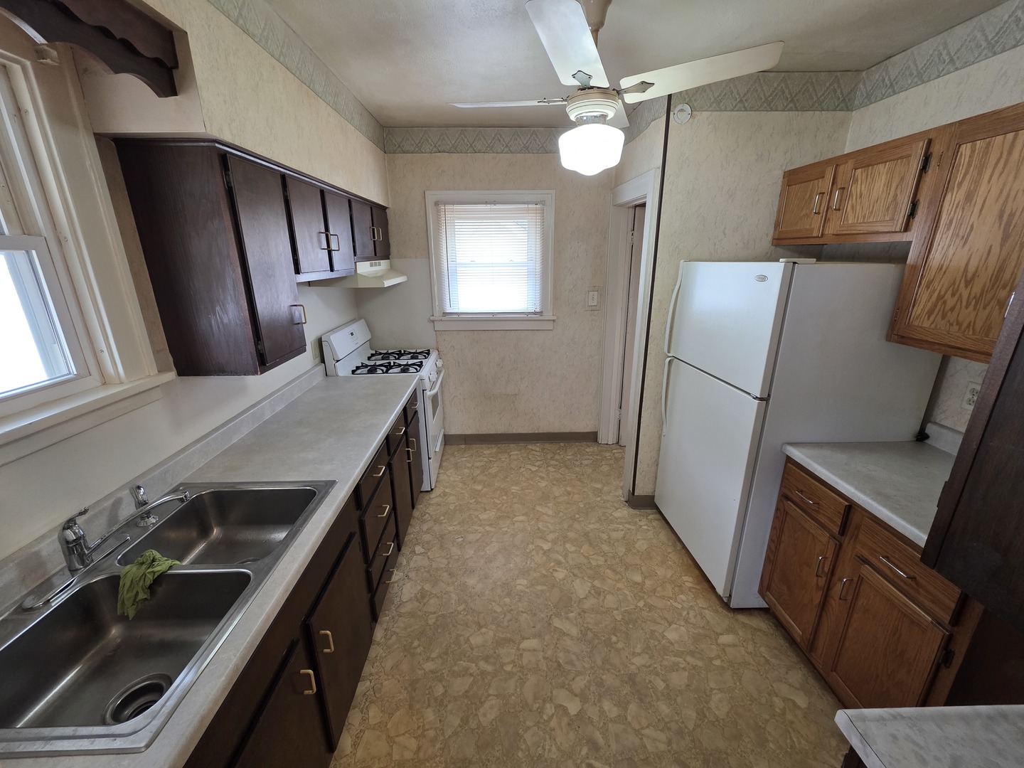 312 East 11th Street Sterling, IL 61081 - Photo 12 of 21 a kitchen that has a sink a refrigerator and a stove
