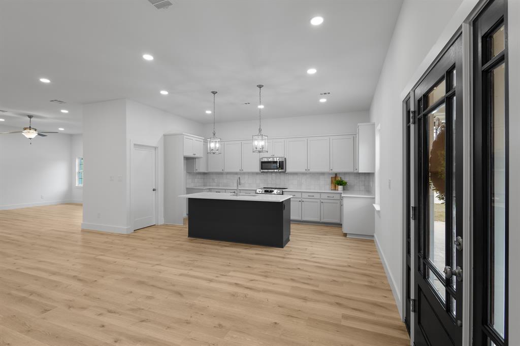 1812 Carpenter Street Bridgeport, TX 76426 - Photo 5 of 30 a large kitchen with a large counter top a sink stainless steel appliances and cabinets