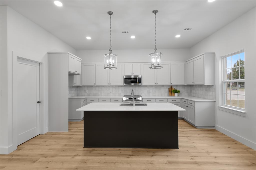 1812 Carpenter Street Bridgeport, TX 76426 - Photo 6 of 30 a kitchen with kitchen island a sink stainless steel appliances and cabinets