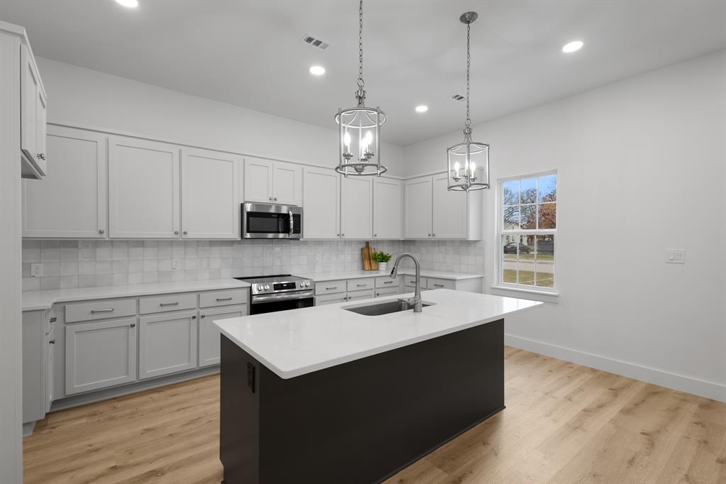 1812 Carpenter Street Bridgeport, TX 76426 - Photo 9 of 30 a kitchen with a sink a stove a microwave and cabinets
