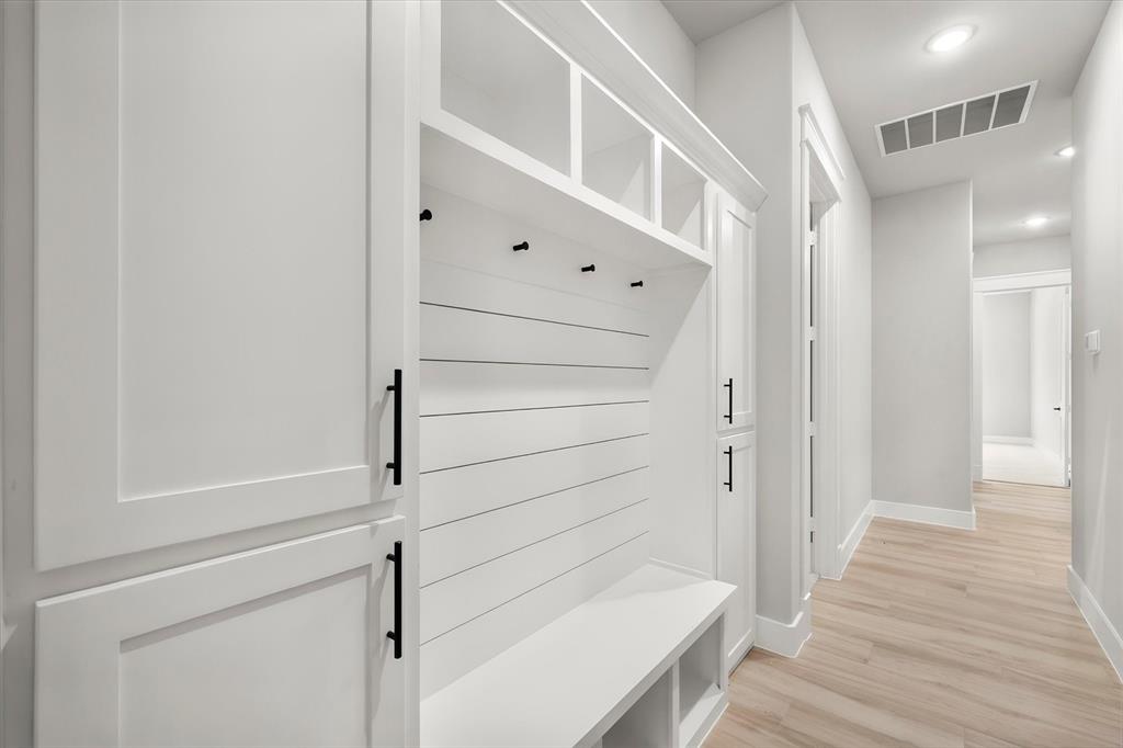 7631 Woodstream Road Midlothian, TX 76065 - Photo 29 of 40 Built-in mudroom bench with cubbies, white shaker cabinetry with black hardware, shiplap detailing, and recessed lighting