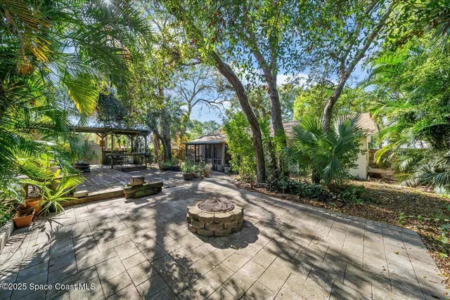 a view of swimming pool with lawn chairs and plants