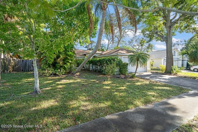a backyard of a house with table and chairs under an umbrella