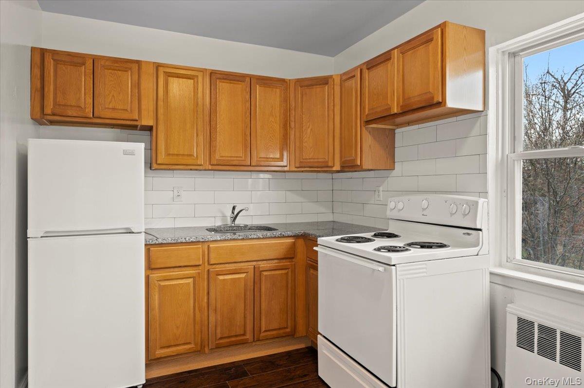 437 Pelham Road, Unit B2 New Rochelle, NY 10805 - Photo 12 of 17 a kitchen with a sink a stove cabinets and a refrigerator