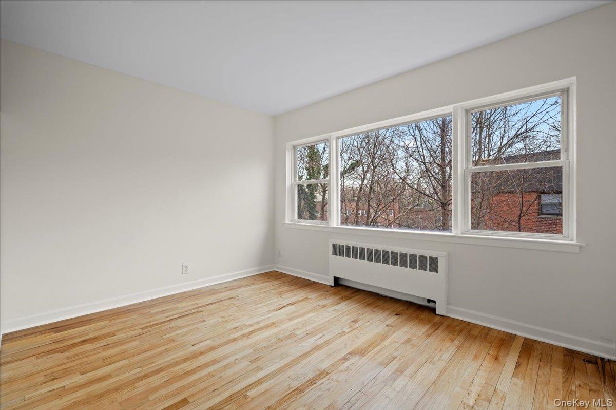 437 Pelham Road, Unit B2 New Rochelle, NY 10805 - Photo 7 of 17 a view of an empty room with wooden floor and a window
