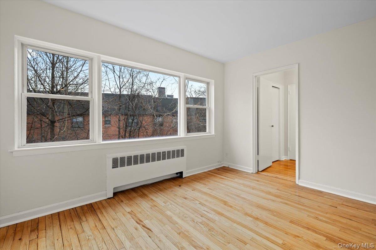 437 Pelham Road, Unit B2 New Rochelle, NY 10805 - Photo 8 of 17 a view of an empty room with wooden floor and a window