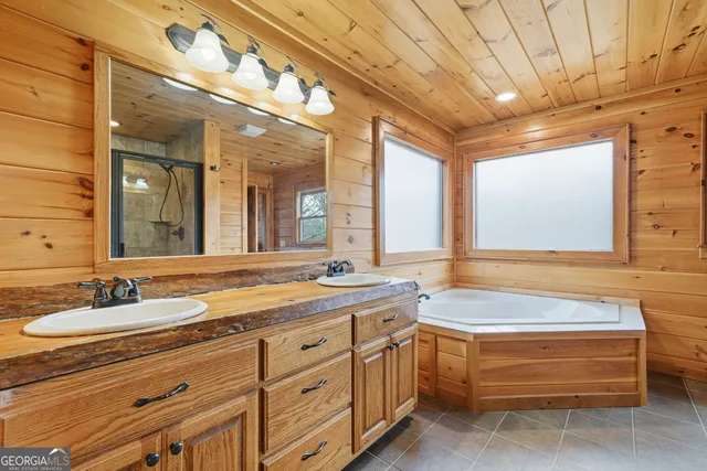 a spacious bathroom with a double vanity sink a large mirror and a bathtub