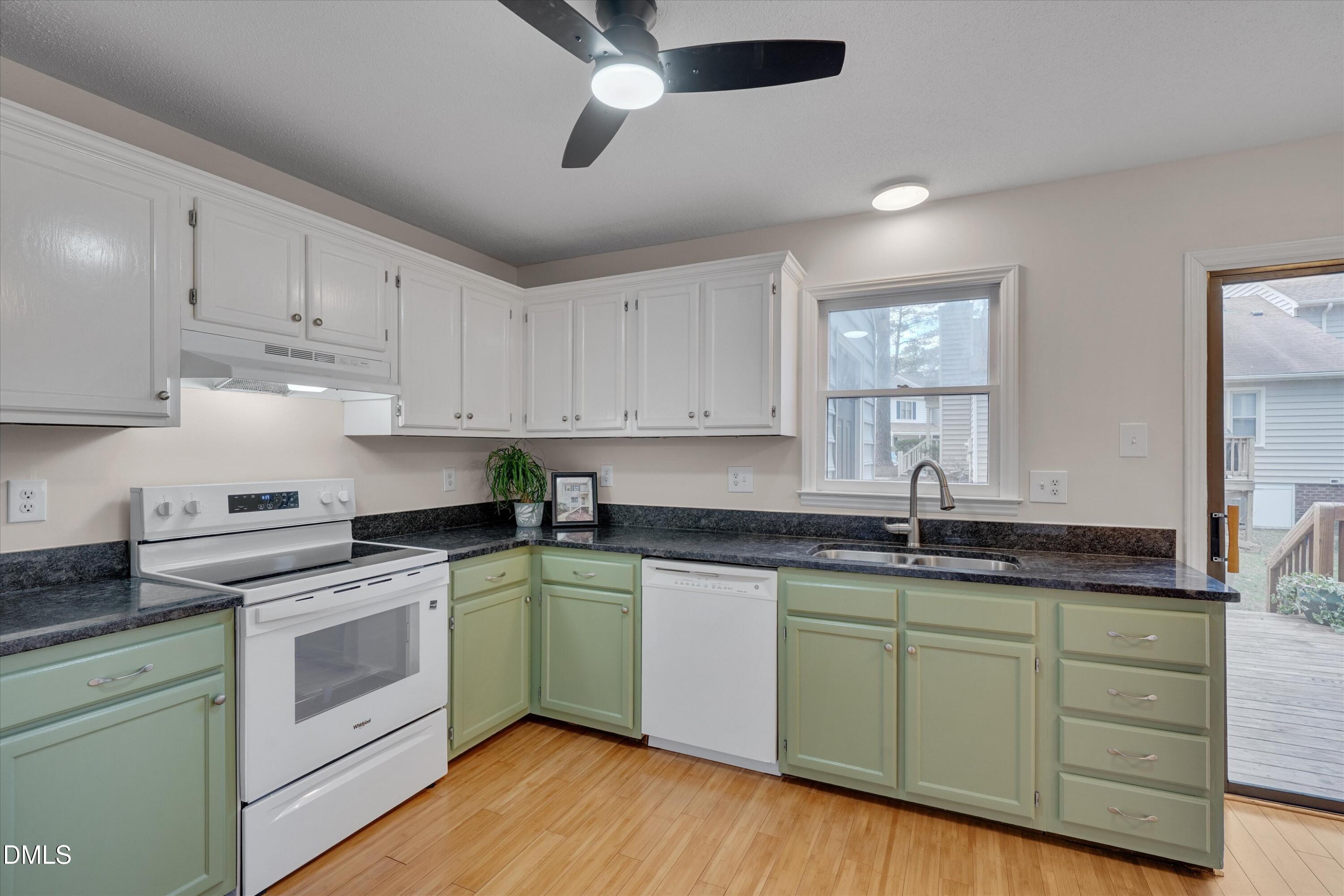6528 Hearthstone Drive Raleigh, NC 27615 - Photo 13 of 32 a kitchen with stainless steel appliances granite countertop a sink and cabinets with wooden floor