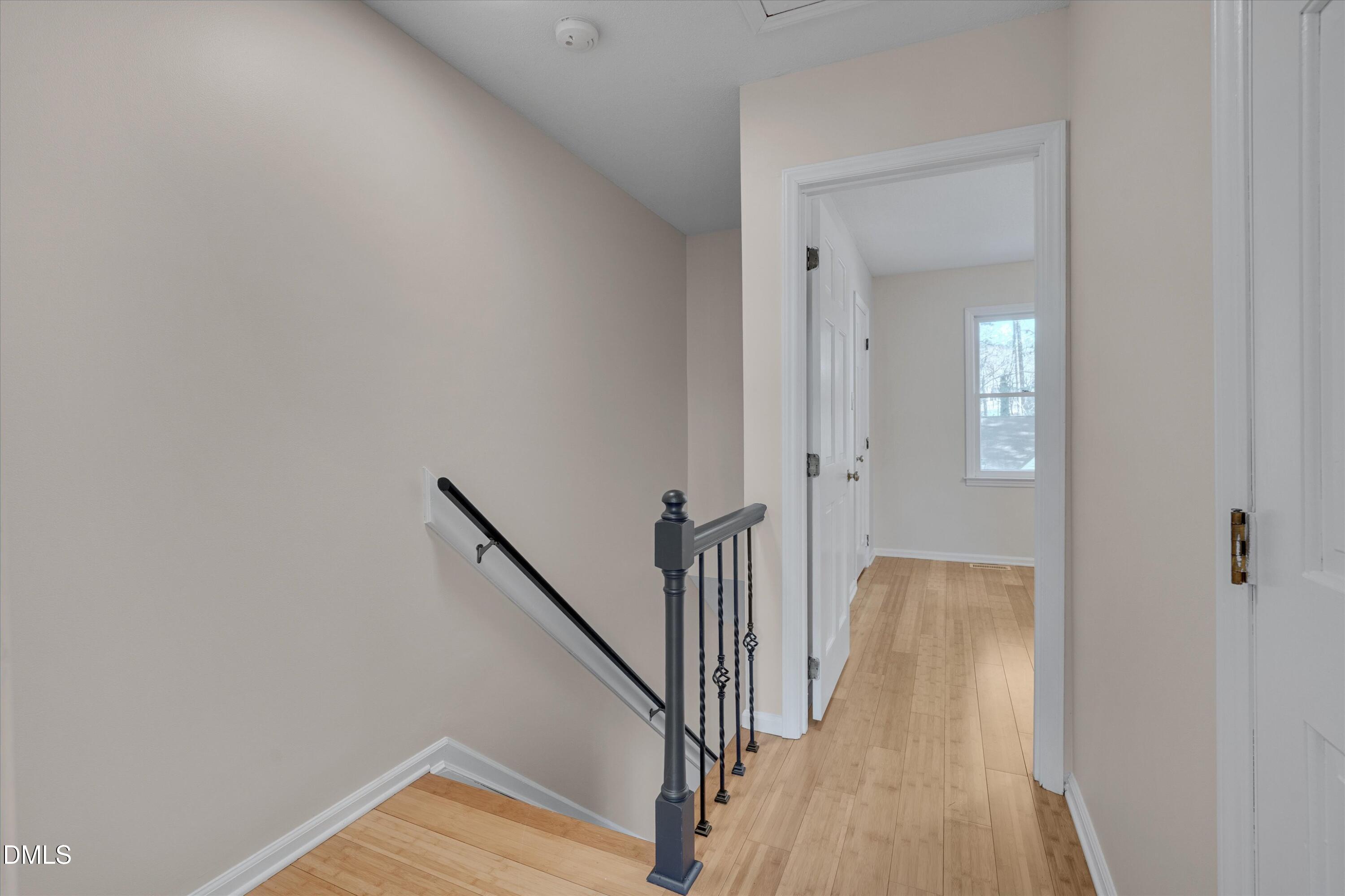6528 Hearthstone Drive Raleigh, NC 27615 - Photo 15 of 32 a view of a hallway with wooden floor and staircase